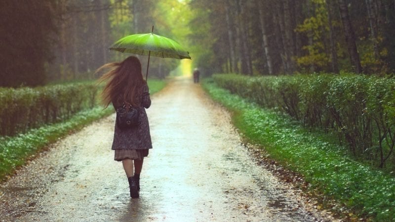 Eine Frau geht bei Regenwetter durch den Wald