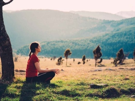 Eine Frau meditiert in der Natur