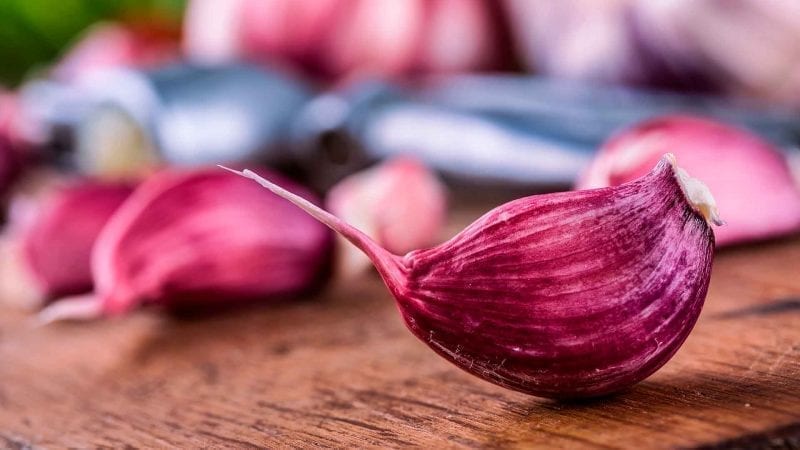 Rote Knoblauchzehen auf einem Holzuntergrund