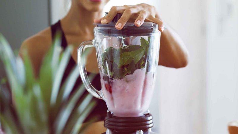 Eine Frau mit Smoothie-Mixer