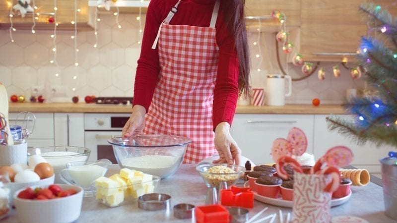 Eine Frau backt in einer Küche mit Weihnachtsdekoration