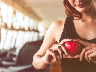 Frau mit Tomatenherz in der Hand