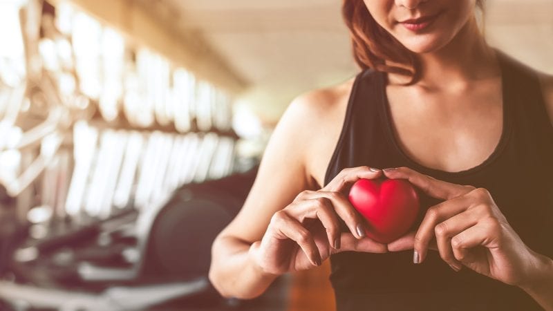 Frau mit Tomatenherz in der Hand