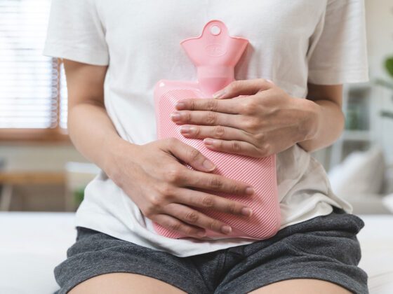 Frau mit Wärmflasche am Bauch