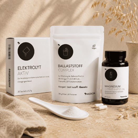 Medicom Ballaststoff Complex und ein Wasserglas und Pulver vor dem Zippbeutel 1 Set drei Produkte von Medicom